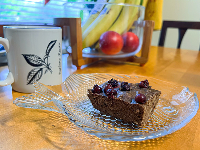 AI:n avulla etsitty brownie resepti, jonka toteutin. Pöydällä brownie ja teekuppi.